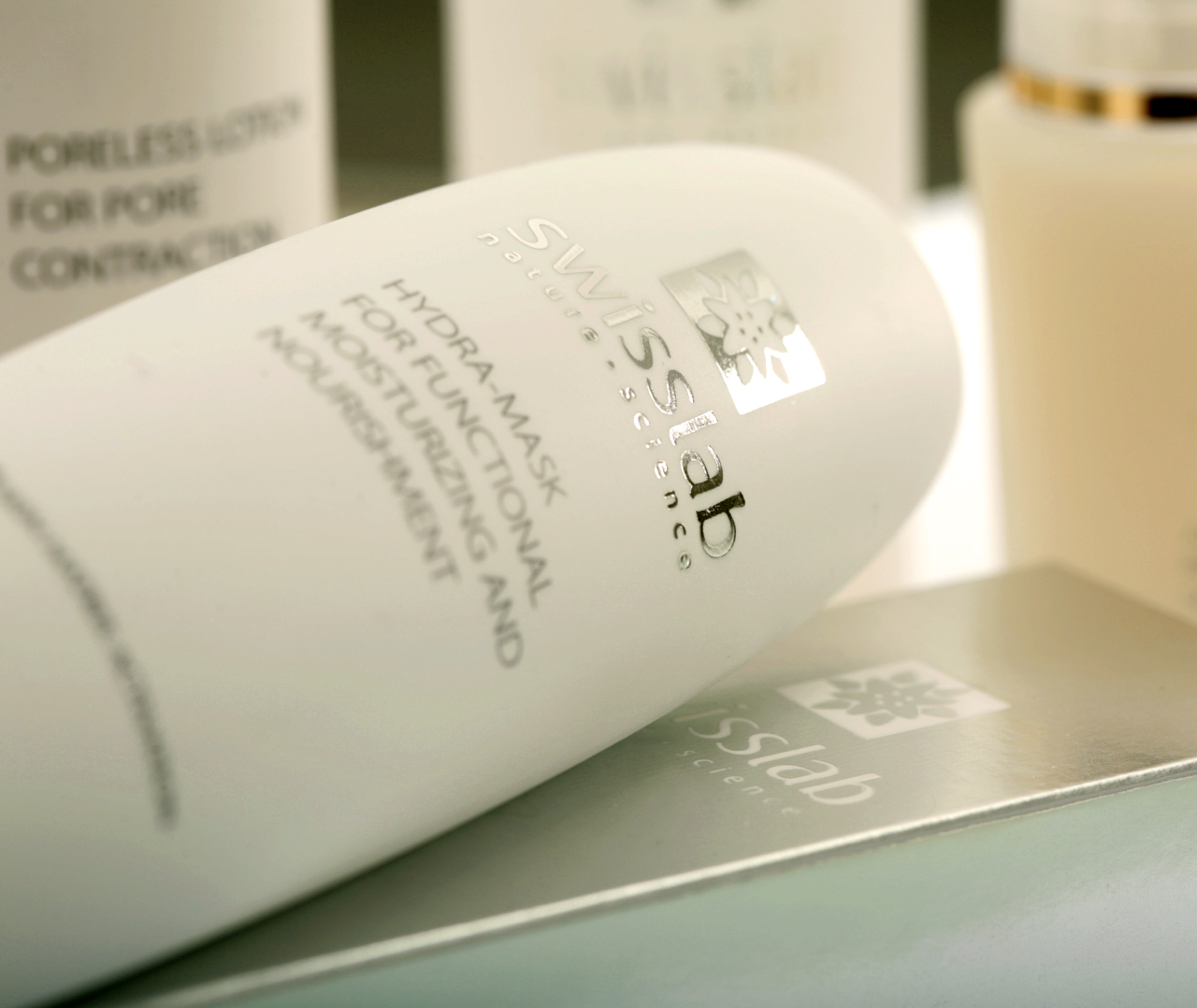 Крупный план белой бутылки Swisslab Hydra Mask для ухода за кожей, на которой изображен логотип в дизайне от Soldis