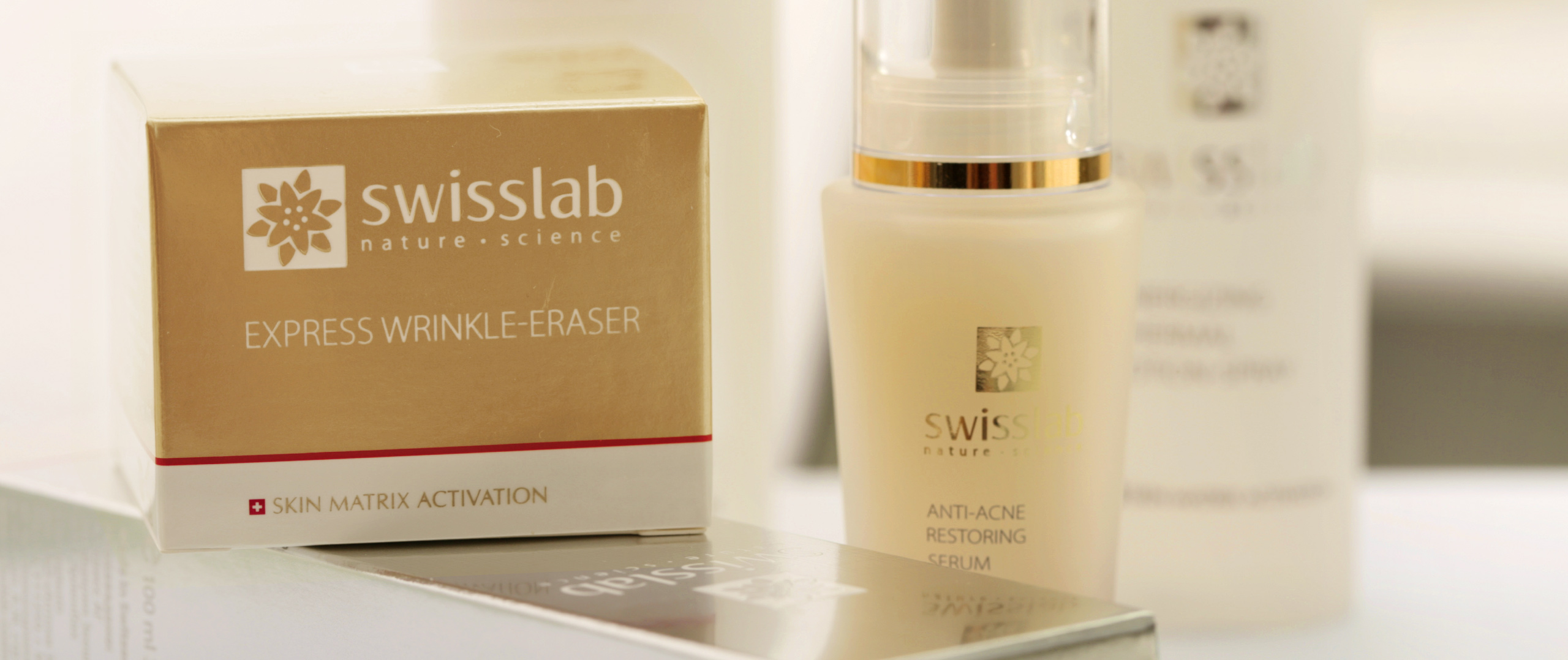 Коробка с надписью Swisslab Express Wrinkle-Eraser и флакон восстанавливающей сыворотки Swisslab Anti-Acne Restoring Serum с логотипом в дизайне от Soldis